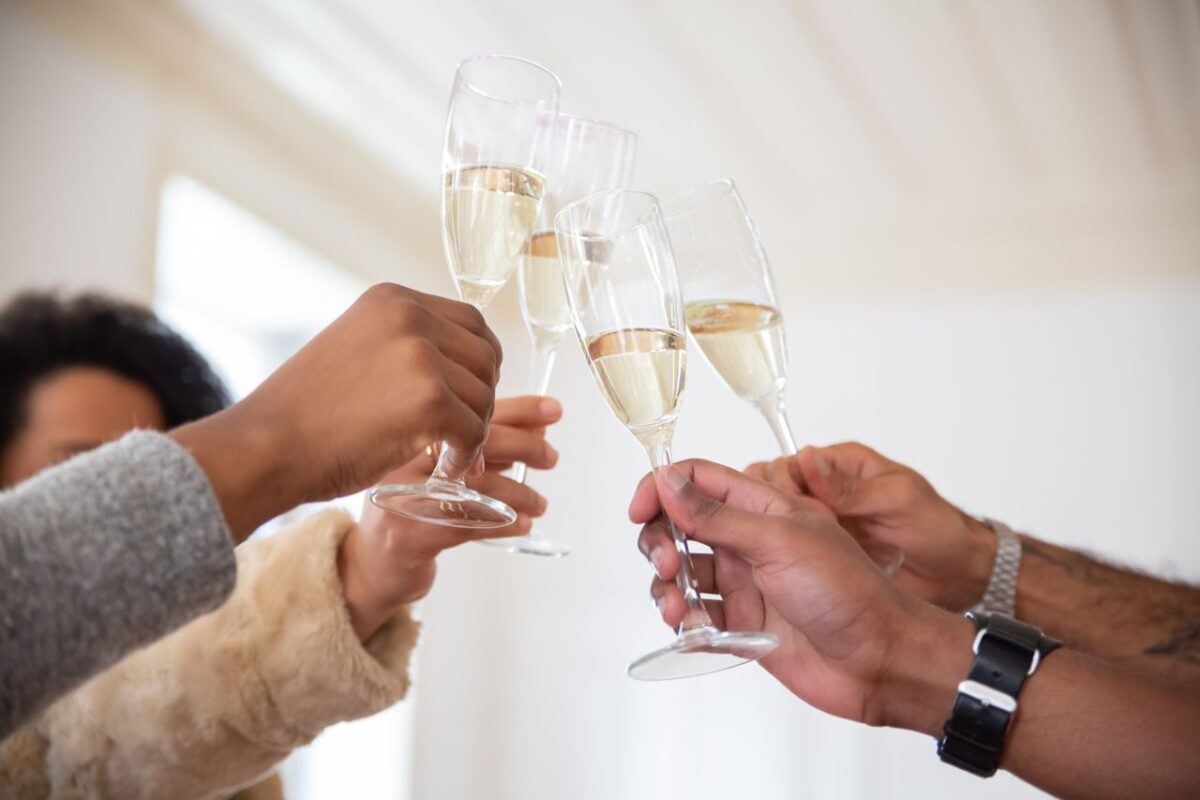 Offres People raising champagne glasses for a celebratory toast indoors. Perfect for party themes.